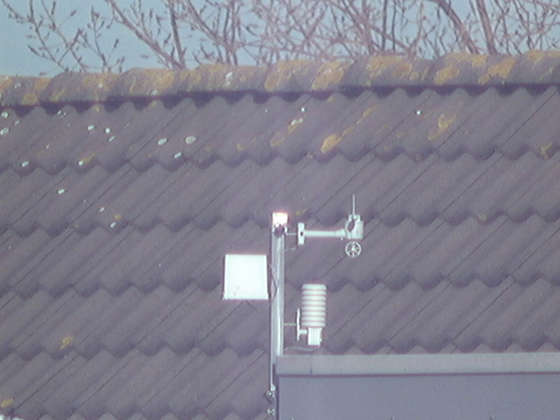 These pictures show the weatherstation on my neighbors house. The first picture is made with my normal photo camera without zooming. The circle shows what the telescope is aimed at. 