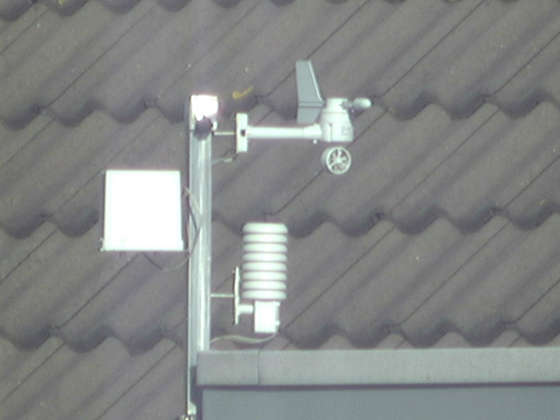 These pictures show the weatherstation on my neighbors house. The first picture is made with my normal photo camera without zooming. The circle shows what the telescope is aimed at. 
