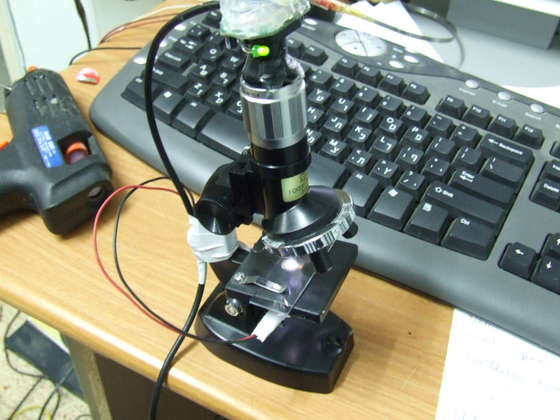 While you view the image via the SW used for the webcam - position it so you get a clear image . you may need to play with it for a while. After you find the exact location use a hot glue gun to fix it to that position. Then tape the wires tidily to the microscope and start taking pictures...