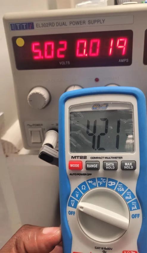 Photographs showing the current drawn by the circuit from a 5-V bench supply, and a multimeter showing a 4.21 V SoC of the Li-ion battery when charging is completed.